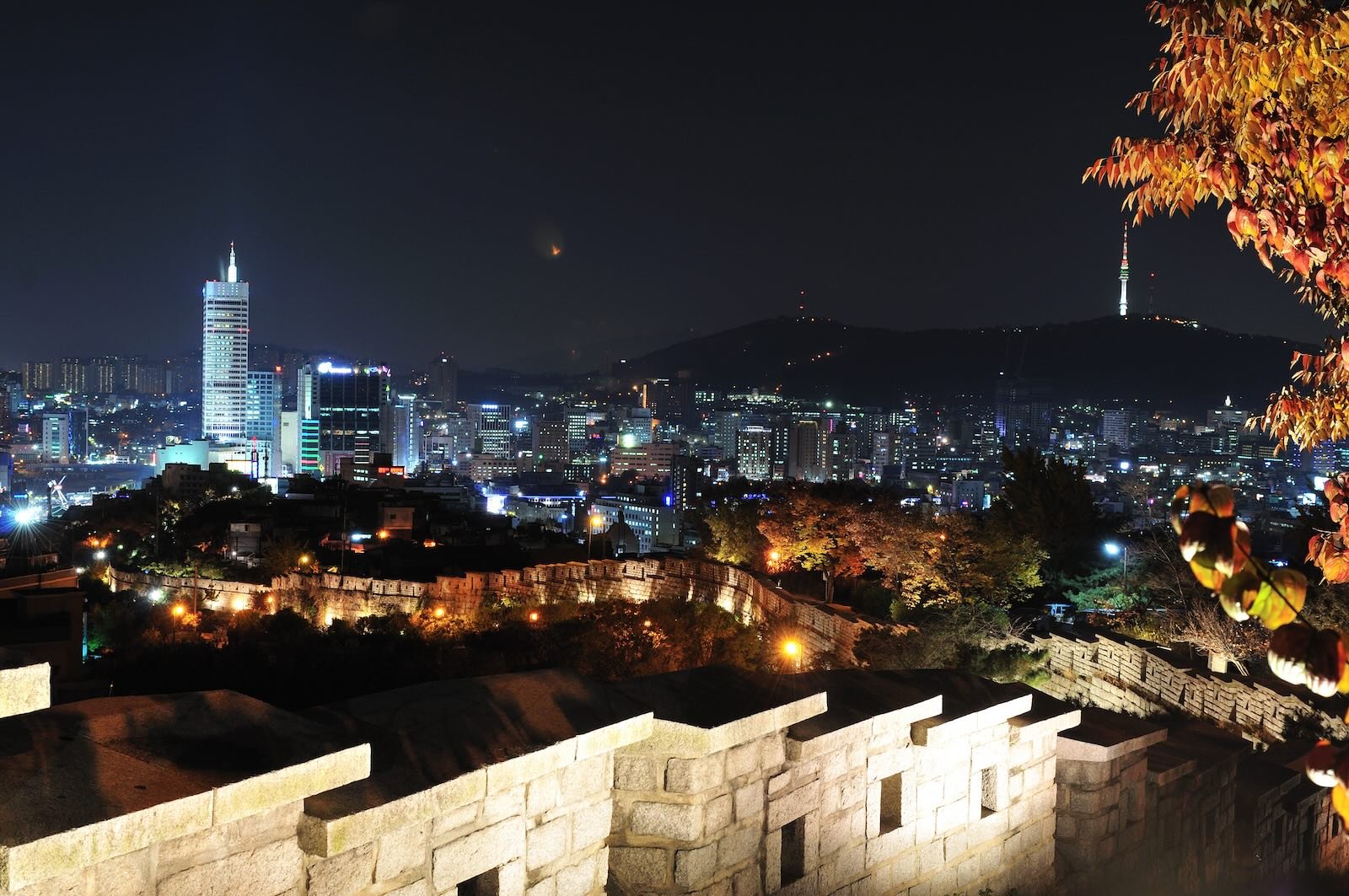 Naksan Park at night with city walls and a view of Seoul in the background