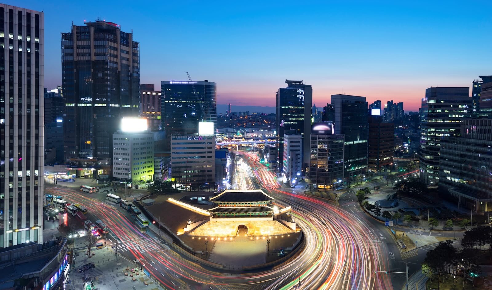 Sungnyemun Gate at dusk with city traffic